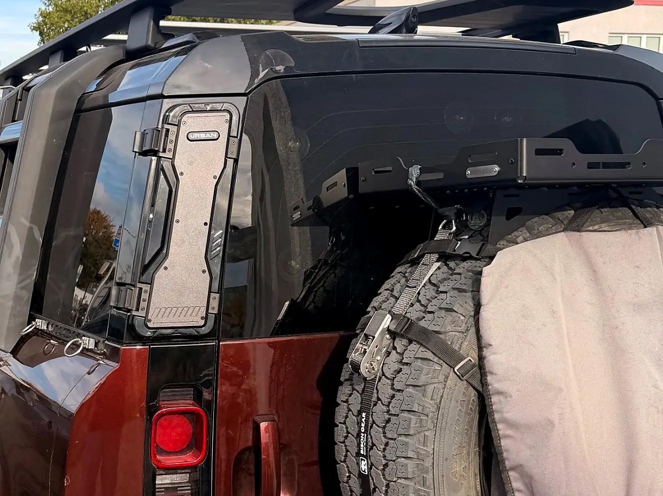 Storage box mounted on the rear D-pillar of the Defender, next to the rear window